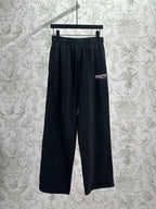 Balenciaga dark wide-leg pants with elastic waistband and logo patch
