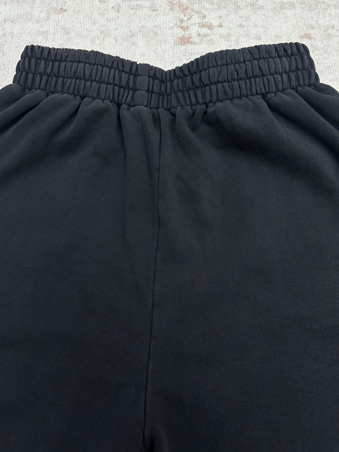 Balenciaga dark pants back view with elastic waistband and center seam