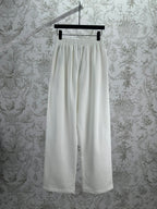 White wide-leg pants with elastic waistband and relaxed drape, front view.