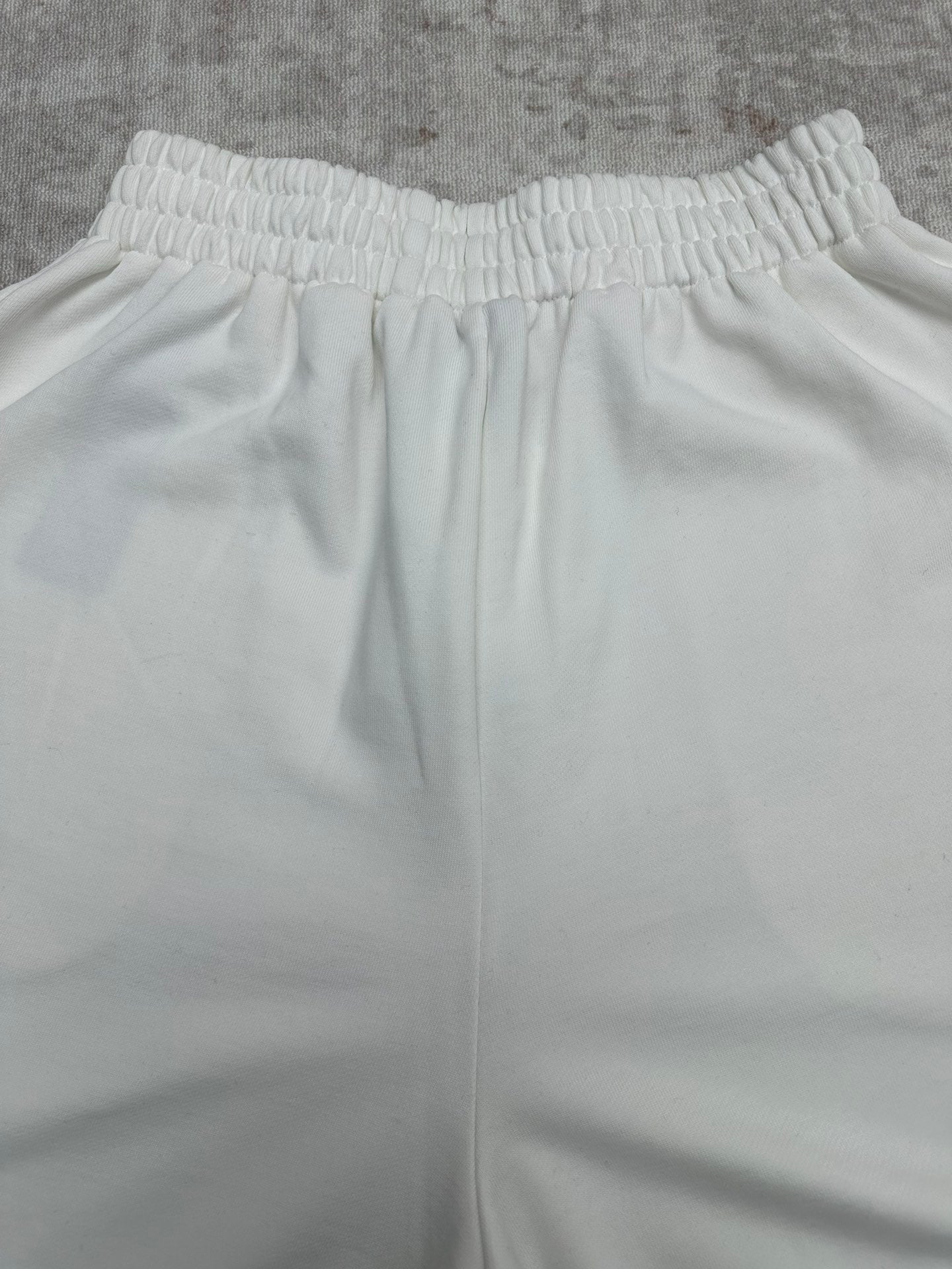 White wide-leg pants with elastic waistband and vertical seam lines, front view.