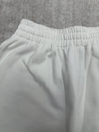 White pants waistband with gathered elastic and smooth fabric, close-up.