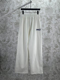 White wide-leg pants with elastic waistband and small Balenciaga logo on the leg.
