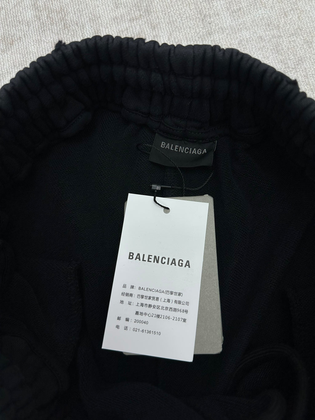 Black Balenciaga pants waistband with brand label and hanging tags