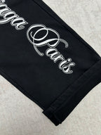 Black pants hem with white cursive logo print