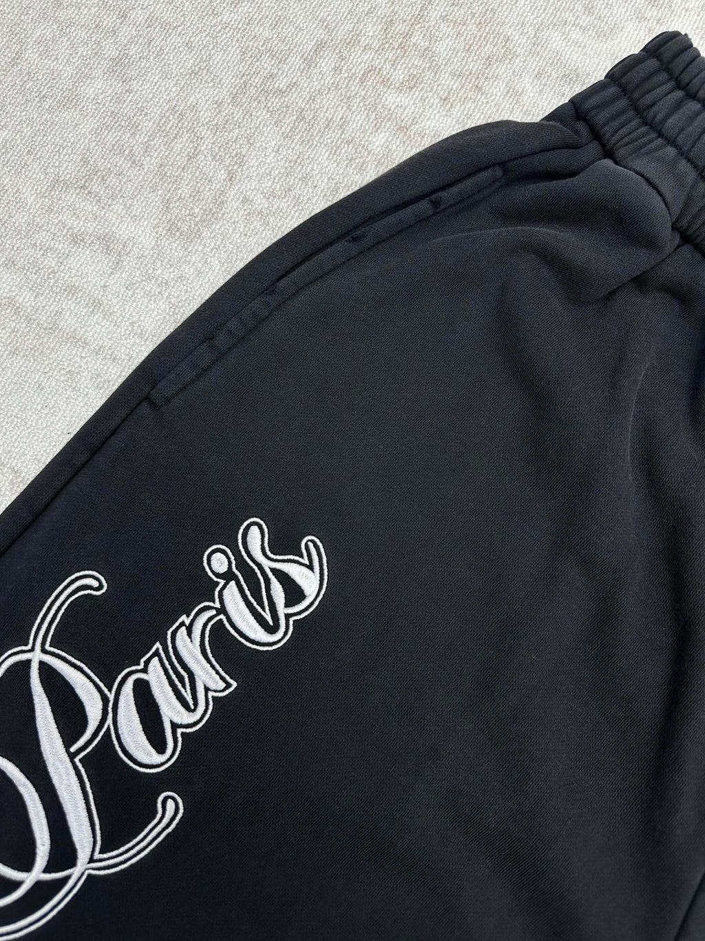 Black pants with white cursive logo across the side panel