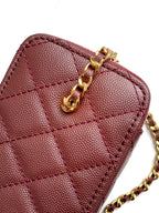 Burgundy Chanel mini bag close-up with gold chain clasp and quilted panels