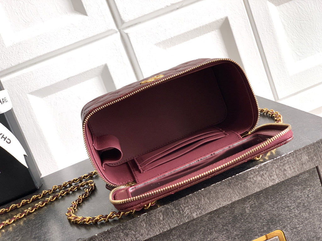 Burgundy Chanel mini flap bag open with interior showing and gold chain strap