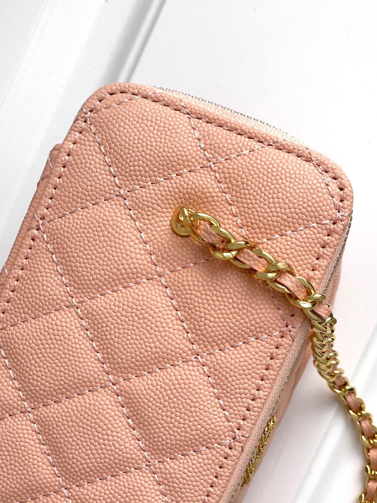 Chanel bag in light pink textured leather with gold chain strap and CC charm