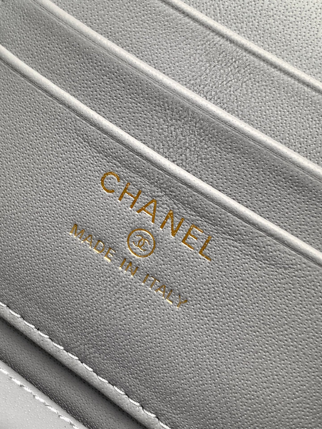 Gray fabric lining with CHANEL and trademark text on a lilac bag