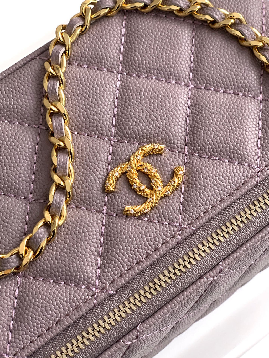 Close-up of lilac quilted bag front with gold-tone Chanel CC logo