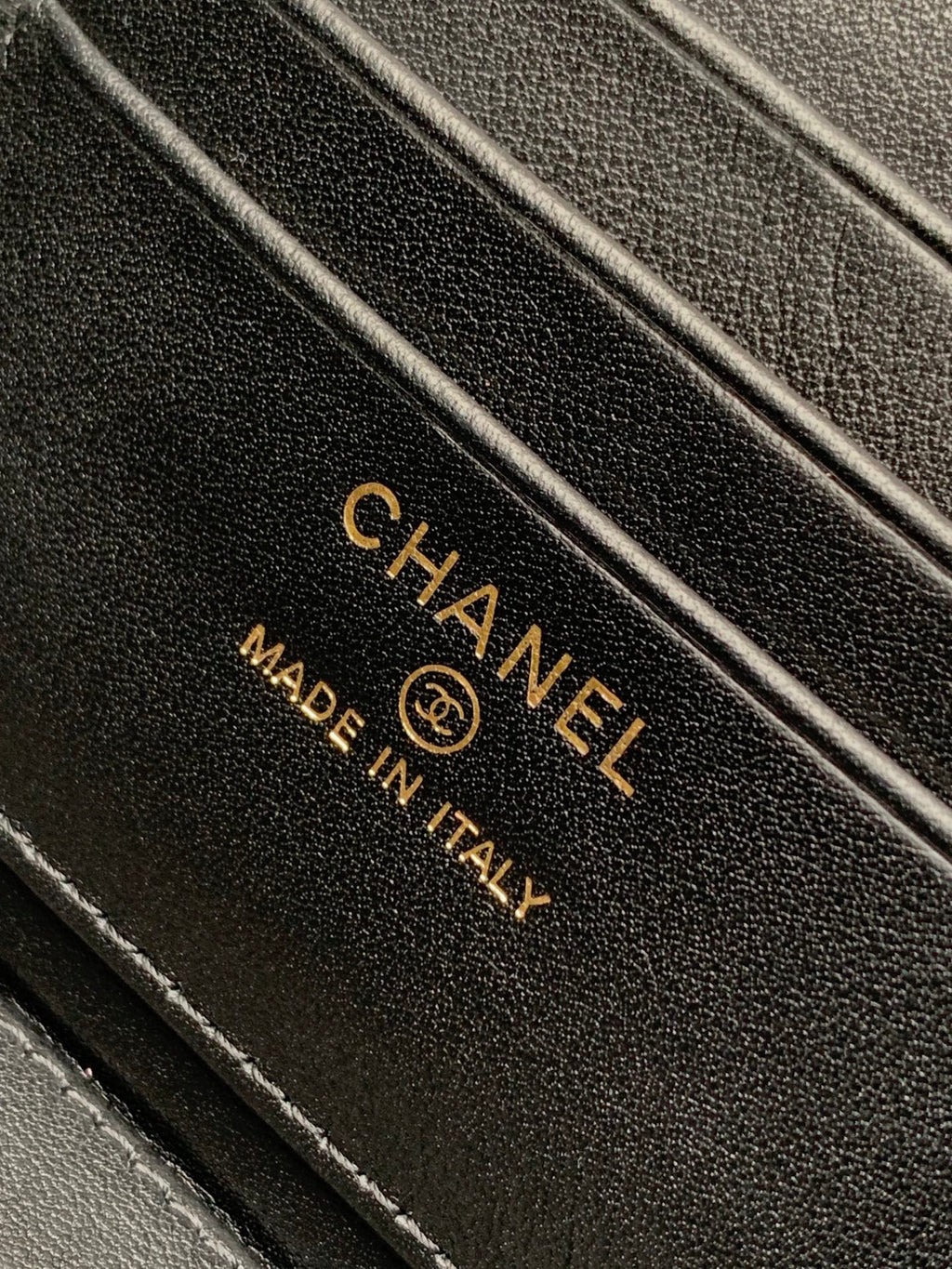 Chanel leather tag with logo and 'MADE IN ITALY' text on black fabric.