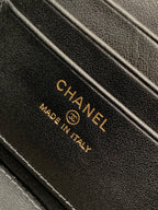 Chanel leather tag with logo and 'MADE IN ITALY' text on black fabric.