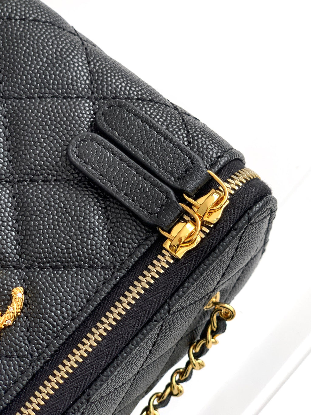 Chanel mini bag corner, black quilted leather with gold zipper pull and chain.