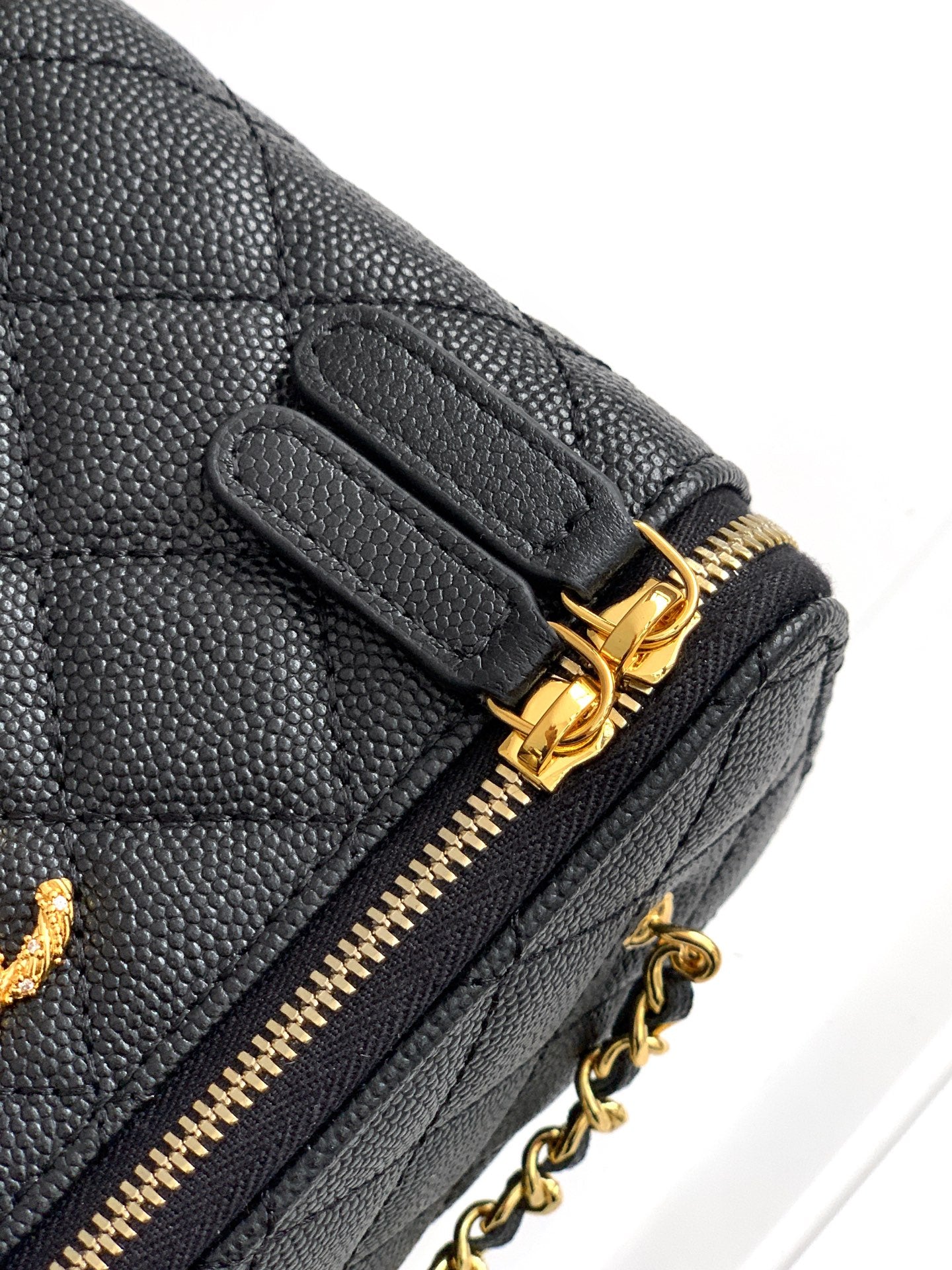 Chanel mini bag corner, black quilted leather with gold zipper pull and chain.