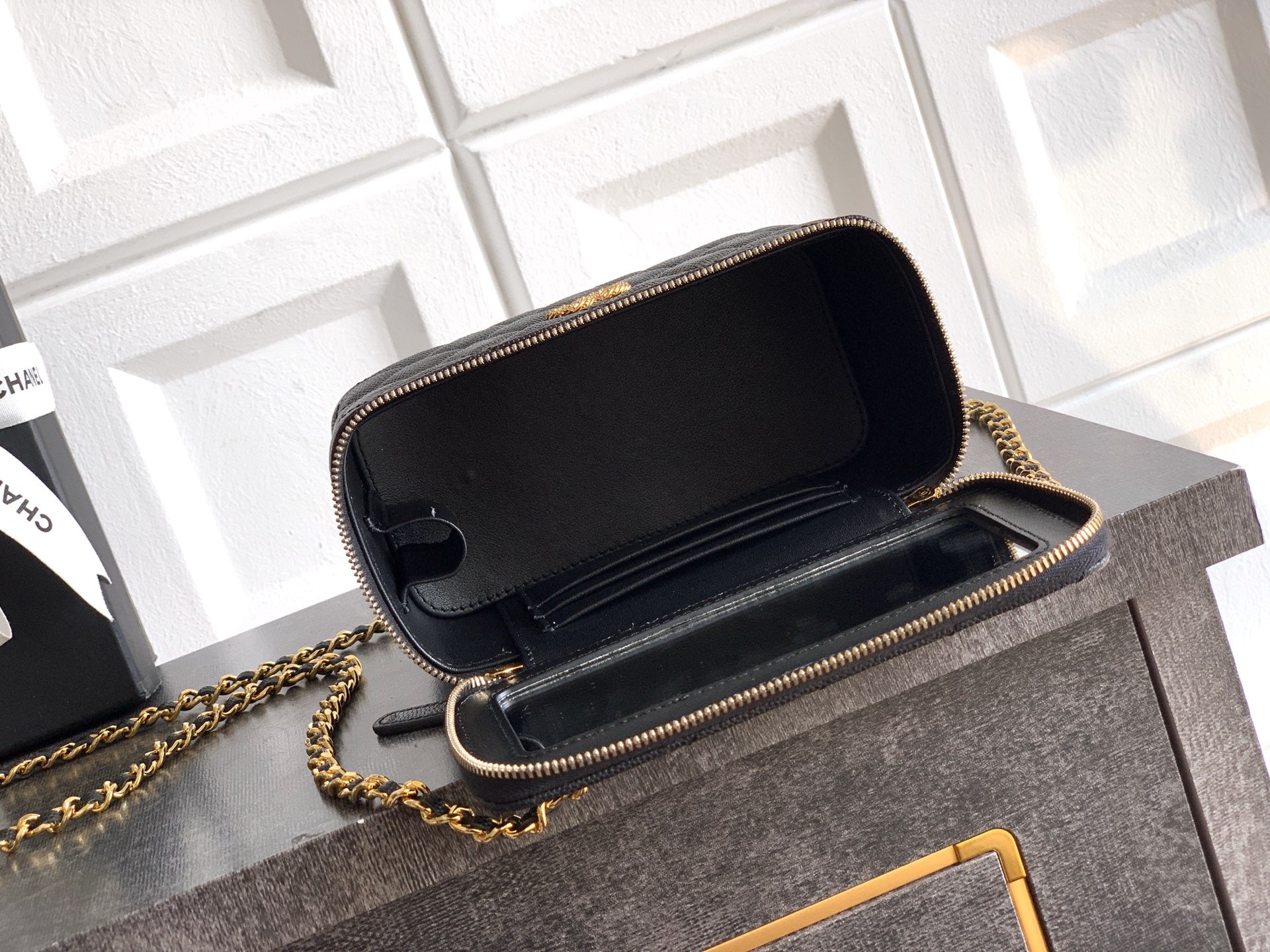 Chanel mini bag with open flap, black quilted leather and gold-tone chain strap.