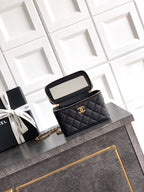 Chanel mini bag with quilted black leather, open flap, gold-tone chain strap.