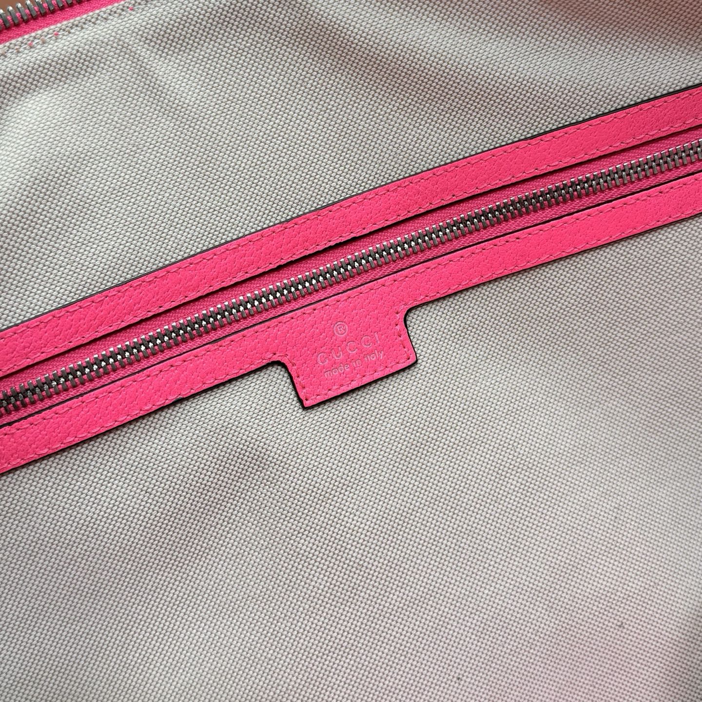 Gucci duffel bag zipper area with pink lining and small fabric logo label