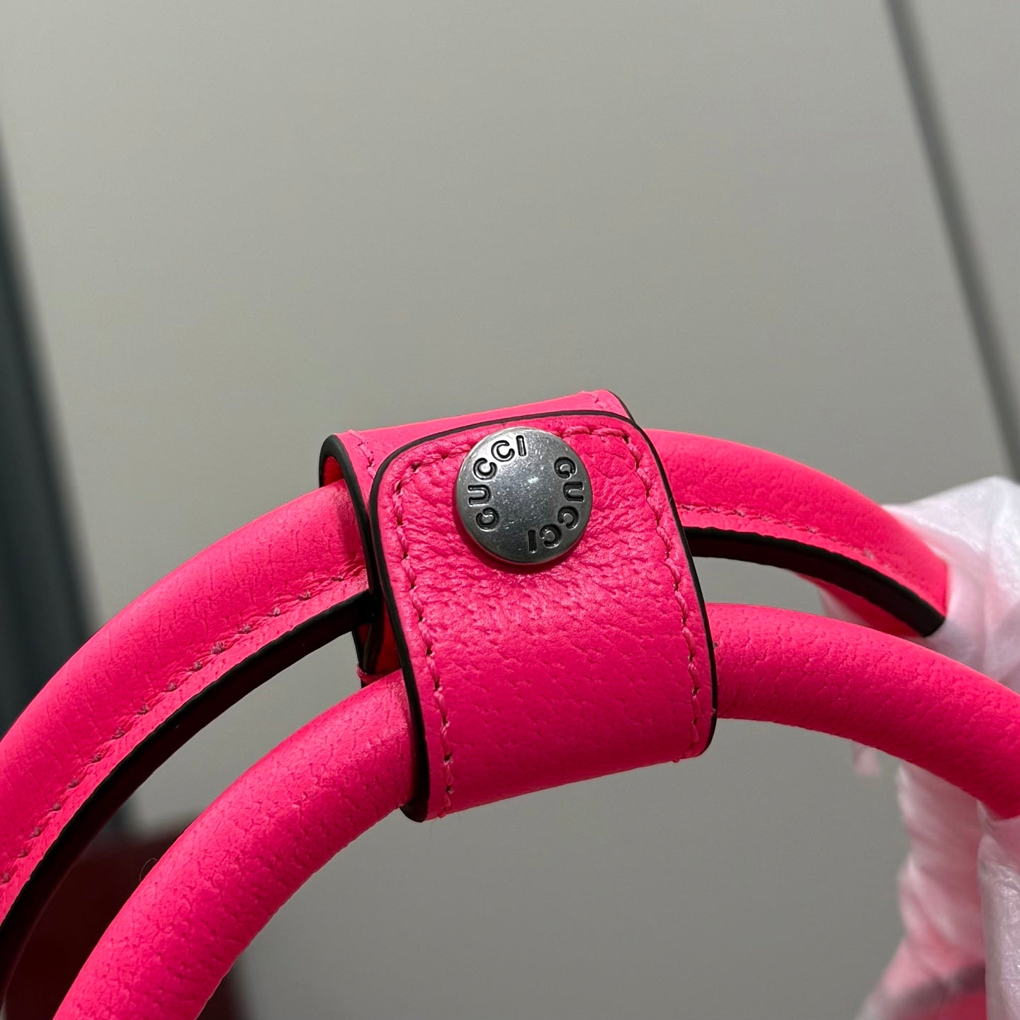 Gucci duffel bag strap end with round metal logo plate, pink leather