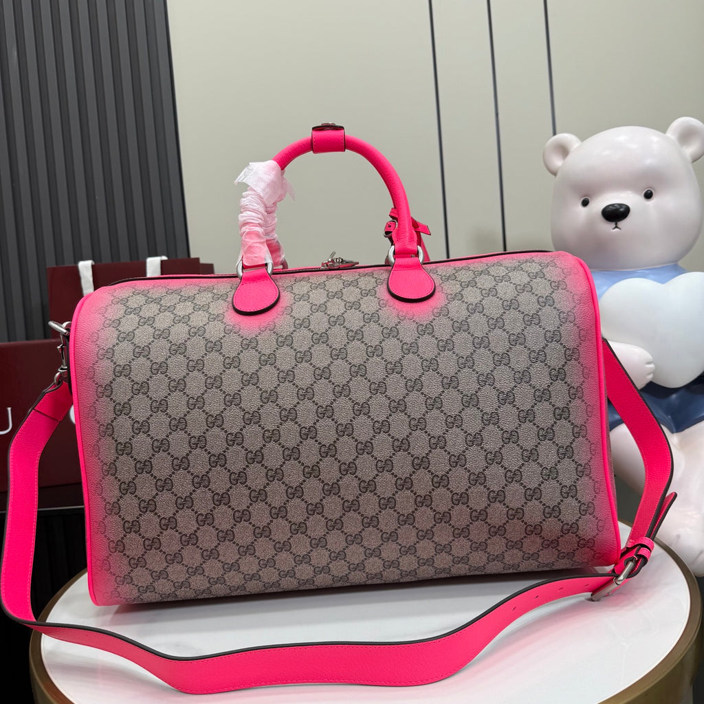 Gucci duffel bag front view with pink handles, GG canvas, and crossbody strap