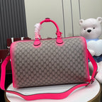 Gucci duffel bag front view with pink handles, GG canvas, and crossbody strap