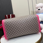 Gucci duffel bag close-up of GG canvas body with bright pink trim and handle