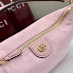 Light pink monogram pouch with gold zipper and snap front logo patch