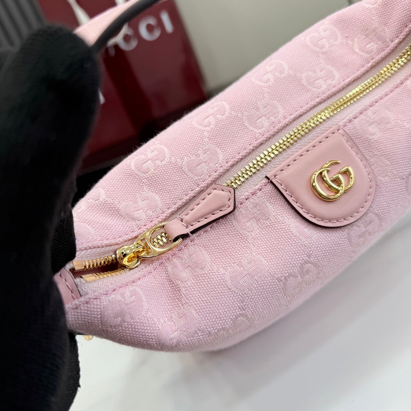 Light pink mini bag with gold zipper pull and front snap logo patch