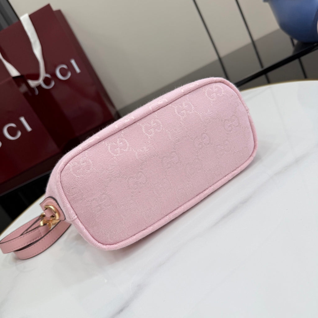 Light pink mini clutch bag with rounded shape and wristlet strap