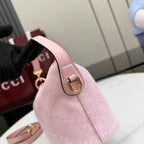Pink mini bag with gold logo emblem and structured side panel