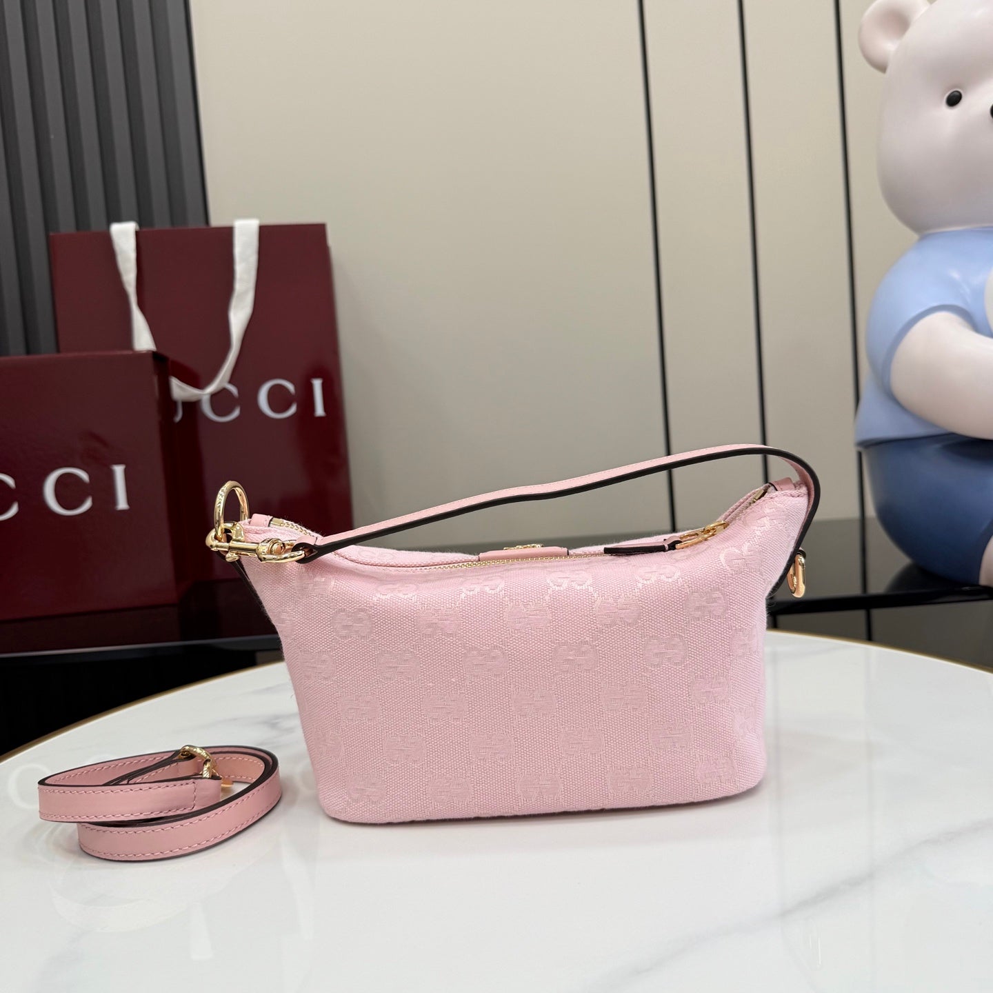 Pink mini crossbody bag with monogram texture and long shoulder strap