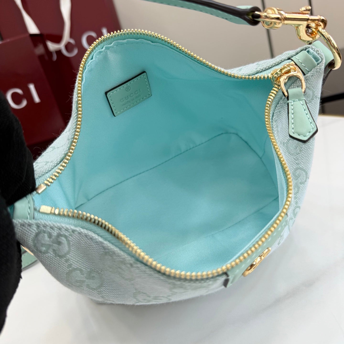 Gucci bag interior in light blue with zipper opening and small logo patch