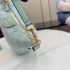 Gucci bag close-up of gold D-ring strap hardware and light blue leather trim