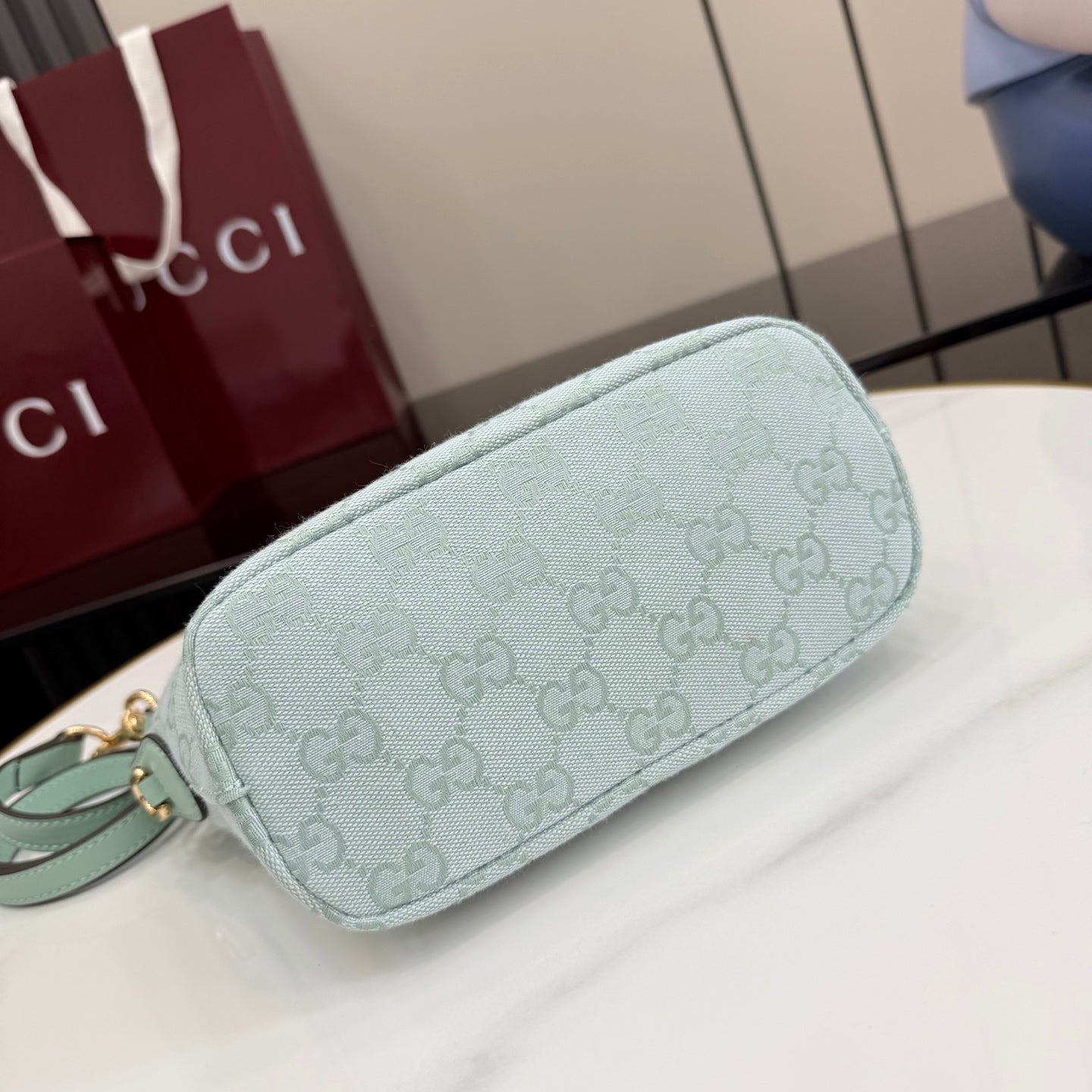 Gucci light blue GG monogram bag, side view with zip closure and smooth trim