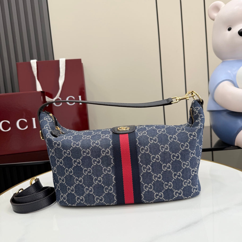 Gucci GG canvas shoulder bag with navy print, red stripe, and leather trim.