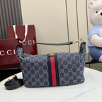 Gucci GG canvas shoulder bag with navy print, red stripe, and leather trim.
