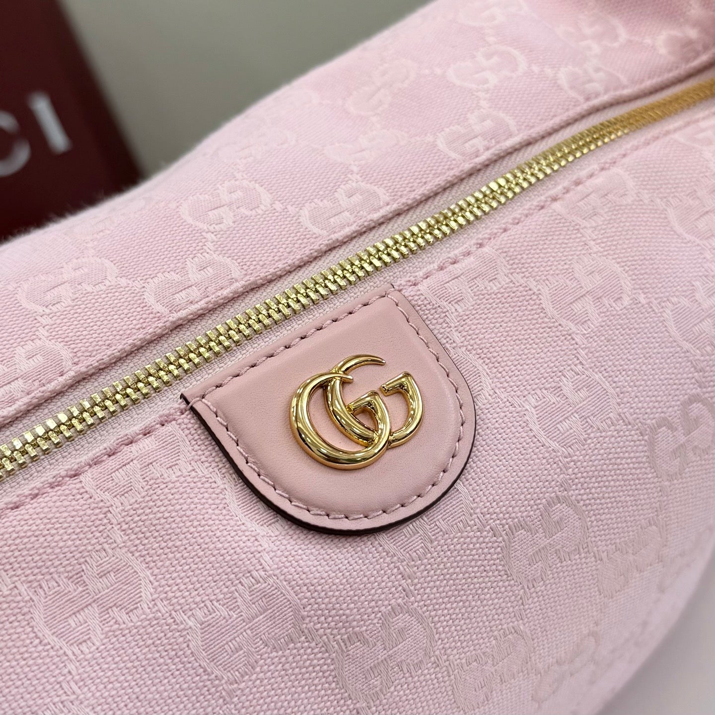 Pink GG monogram zip panel with gold zipper and oval leather G logo patch.