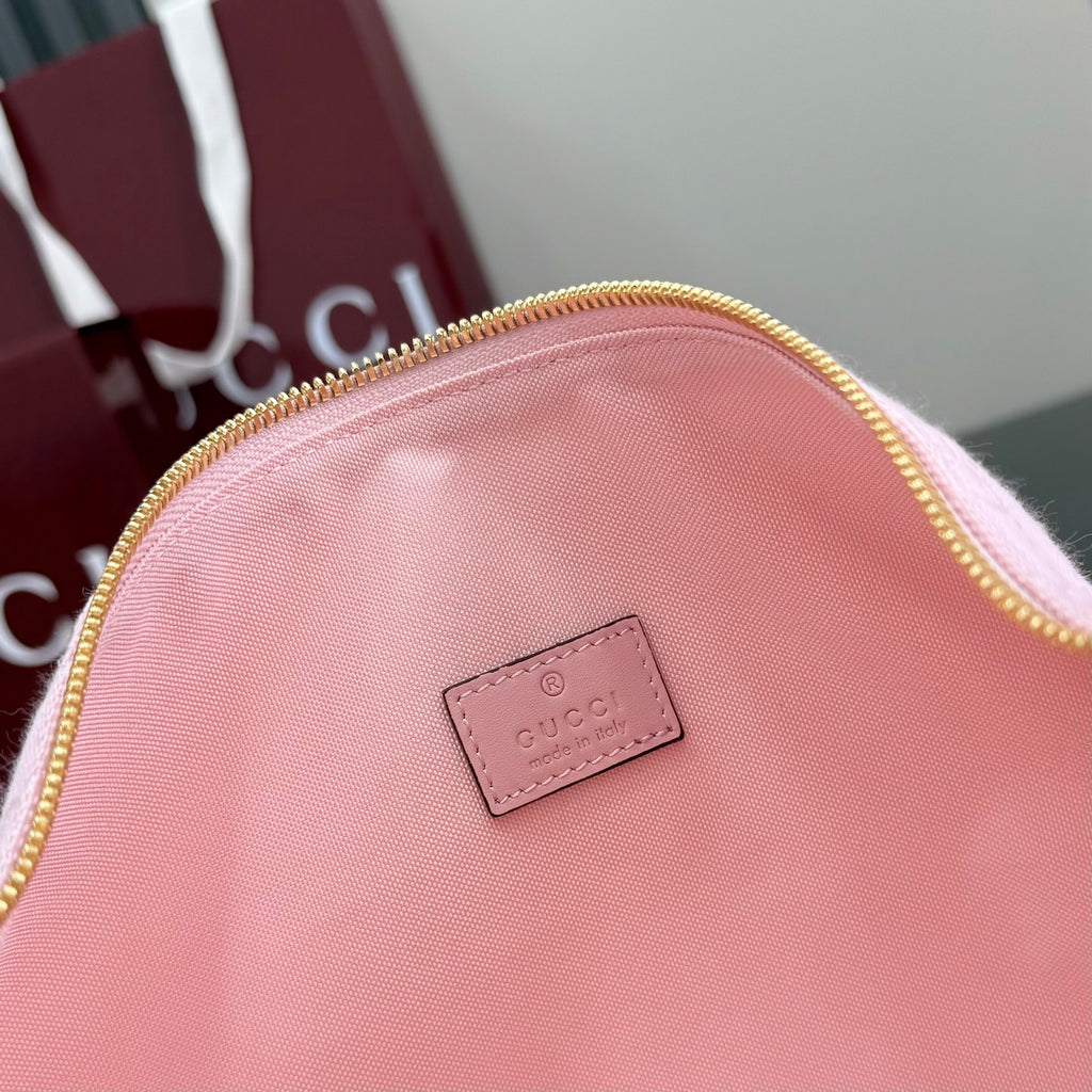 Pink bag back with small rectangular Gucci logo patch, gold zip rim, monogram fabric.