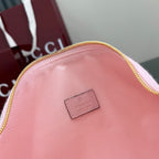 Pink bag back with small rectangular Gucci logo patch, gold zip rim, monogram fabric.