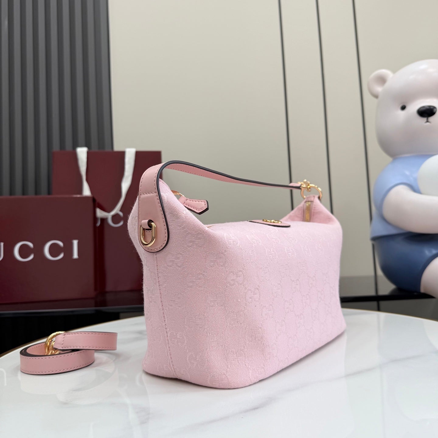 Pink GG monogram hobo bag, gold hardware, leather trim, adjustable strap, zip top.
