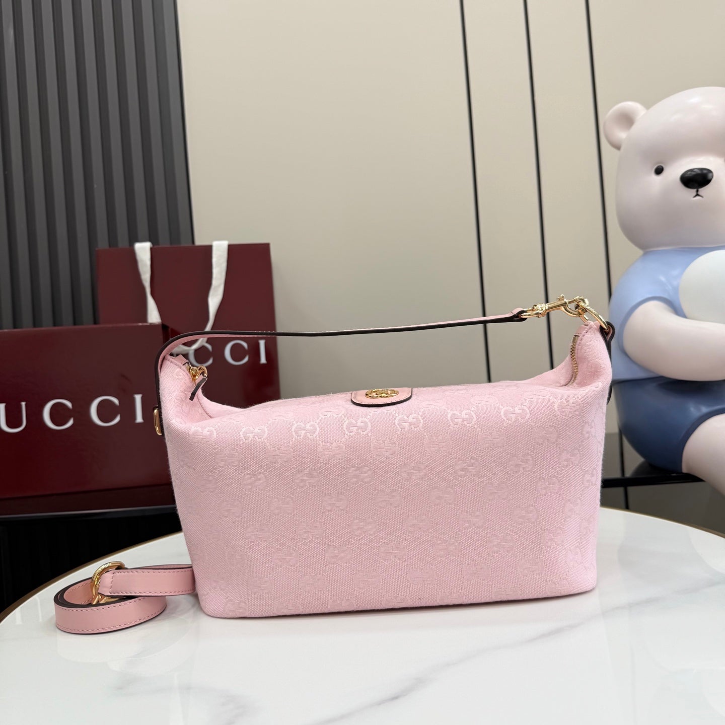 Pink shoulder bag with GG monogram, gold-tone chain strap, zip-top closure.