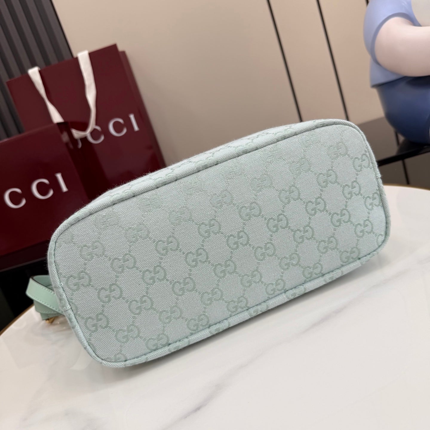 Light blue Gucci hobo bag with GG monogram canvas and rounded side profile, gold trim