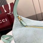 Gucci hobo bag close-up: light blue strap with gold clasp and GG monogram texture