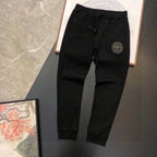 Black jogger pants with drawstring waist and small round logo patch on the thigh
