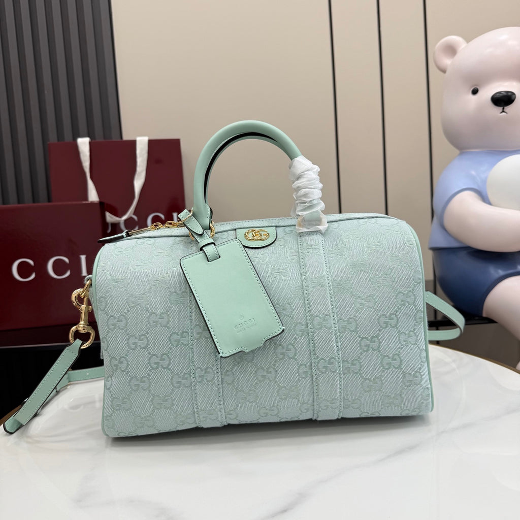 Mint GG-pattern handbag with top handles, front tab detail, and detachable shoulder strap.