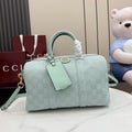 Mint GG-pattern handbag with top handles, front tab detail, and detachable shoulder strap.