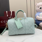 Mint GG-pattern handbag with top handles, front tab detail, and detachable shoulder strap.