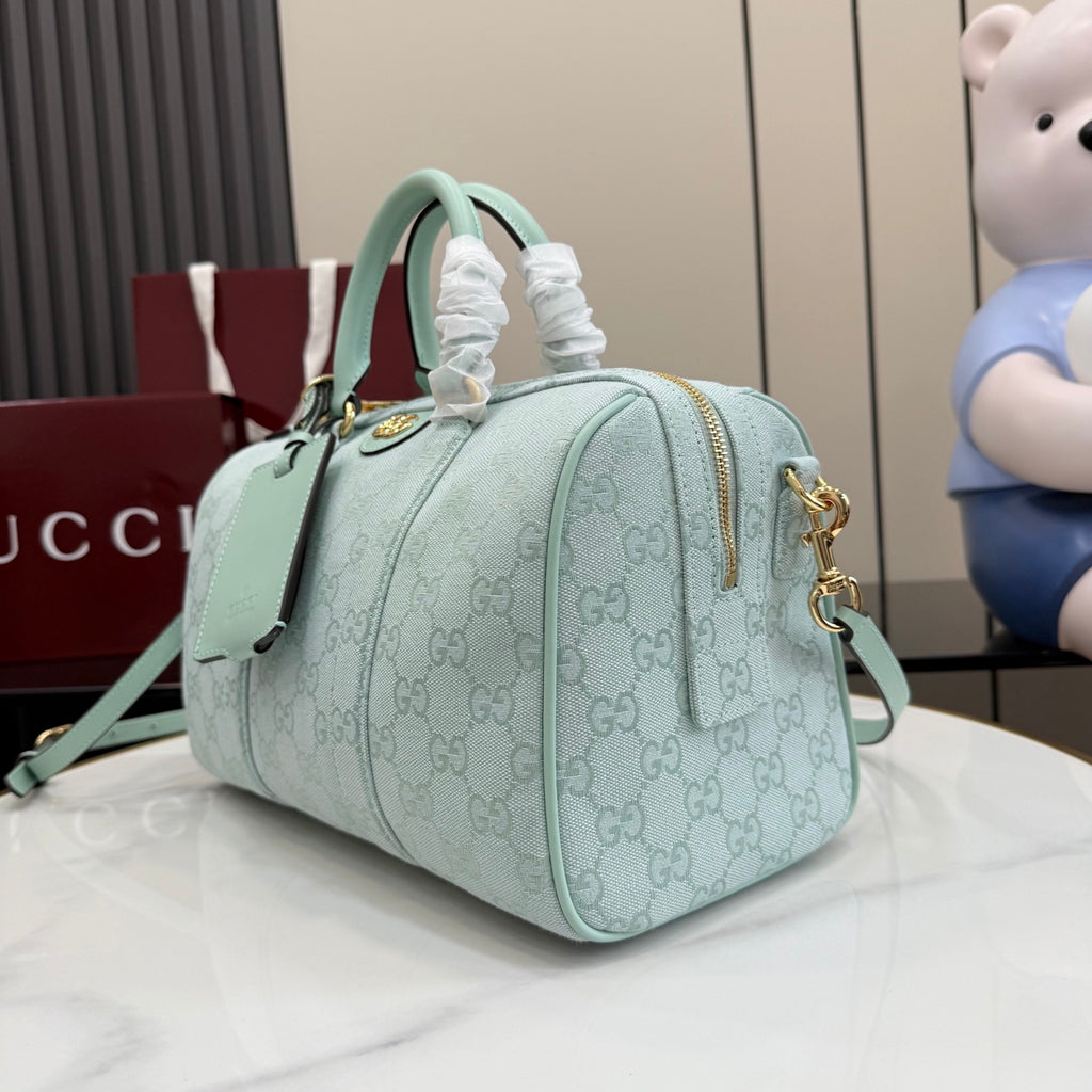 Mint GG-pattern handbag shown at an angle with top handles and gold zipper hardware.