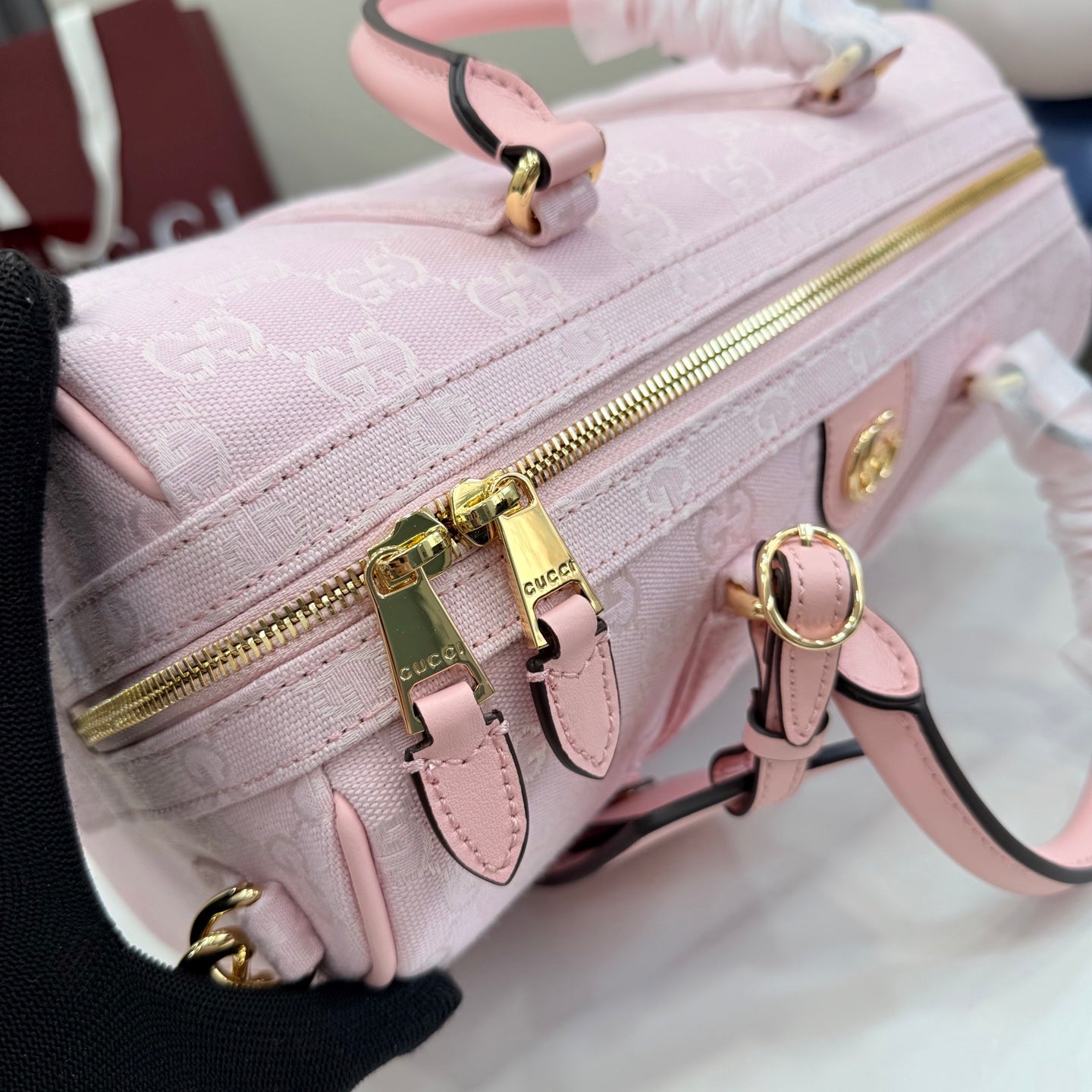 Gucci pale pink crossbody bag with G monogram, close-up of zipper and gold hardware