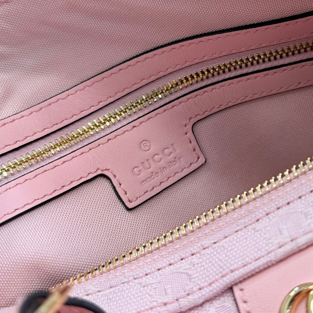 Gucci pale pink bag close-up of leather patch logo and gold zipper track
