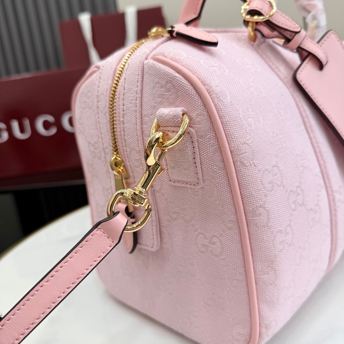 Gucci pale pink bag with G monogram print, front zip pocket and gold key clasp charm